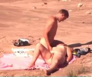 Hij neukt zijn vrouw op het strand niet wetend dat ze gefilmd worden